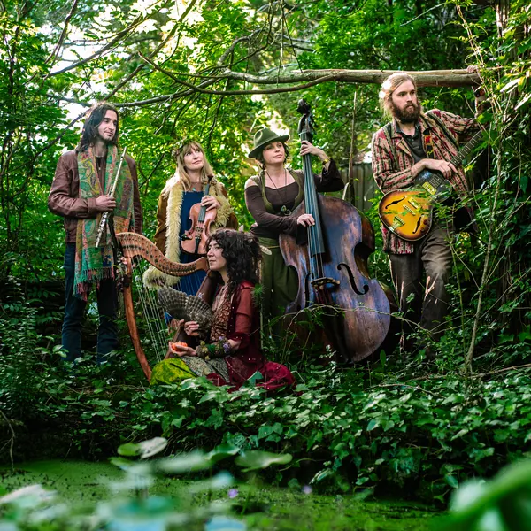 Folk band posing with their instruments in a forest